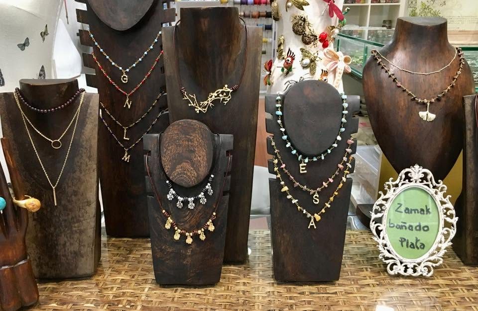 Expositores de madera con collares de zamak bañado en plata y piedras de colores