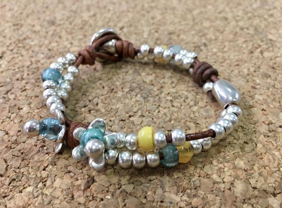 Pulsera artesanal de cuero trenzado con bolas de zamak bañado en plata y cristal de colores
